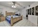 Bright primary bedroom featuring tile floors, white walls, ceiling fan, and a comfortable bed at 279 Maple Ave, Palm Harbor, FL 34684