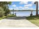 A concrete boat ramp slopes into a lake surrounded by trees and greenery on a sunny day at 279 Maple Ave, Palm Harbor, FL 34684