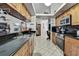 Galley kitchen with wood cabinets, black countertops, and stainless steel appliances at 279 Maple Ave, Palm Harbor, FL 34684