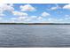 A wide and tranquil view of a smooth lake, showing distant trees and a cloudy sky at 279 Maple Ave, Palm Harbor, FL 34684