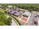 Aerial view of community pickleball and basketball courts near a beautiful lake and lush trees at 3013 Appleblossom Trl, Spring Hill, FL 34606