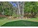 Lush backyard with decorative garden and mature trees, creating a serene and private outdoor space at 3013 Appleblossom Trl, Spring Hill, FL 34606