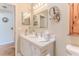 Well-lit bathroom featuring a white vanity, decorative mirror, and vanity mirror at 3013 Appleblossom Trl, Spring Hill, FL 34606