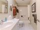 Bright bathroom featuring a white vanity, wooden cabinet, and a shower-tub combo with tiled walls at 3013 Appleblossom Trl, Spring Hill, FL 34606