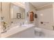 Bright bathroom with a white vanity, large mirror, and a shower-tub combo with white tiled walls at 3013 Appleblossom Trl, Spring Hill, FL 34606