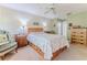 This bedroom features a bed with floral bedding and a ceiling fan and easy access to a private bath at 3013 Appleblossom Trl, Spring Hill, FL 34606