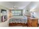 This bedroom features a bed with floral bedding, lots of storage, and natural light at 3013 Appleblossom Trl, Spring Hill, FL 34606