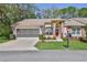 Charming single-story home with a well-manicured lawn, screened garage, and an inviting brick-accented entryway at 3013 Appleblossom Trl, Spring Hill, FL 34606
