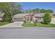 Charming single-story home featuring a screened garage, brick accents, and an inviting front yard with lush greenery at 3013 Appleblossom Trl, Spring Hill, FL 34606