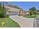 Lovely home with a screened garage, brick accents, an American flag, and a well-maintained front lawn at 3013 Appleblossom Trl, Spring Hill, FL 34606