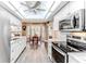 Bright eat-in kitchen features a skylight, ceiling fan, white cabinets, and stainless steel appliances at 3013 Appleblossom Trl, Spring Hill, FL 34606