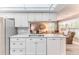 White kitchen with stainless steel appliances, cabinetry, and breakfast bar open to living area at 3013 Appleblossom Trl, Spring Hill, FL 34606