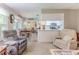 Cozy living room with hardwood floors and a dining area featuring natural light and a kitchen with white cabinets at 3013 Appleblossom Trl, Spring Hill, FL 34606