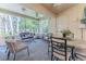 Inviting screened porch with cozy seating, a ceiling fan, and serene views of the surrounding greenery at 3013 Appleblossom Trl, Spring Hill, FL 34606