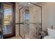 Stylish bathroom features a glass shower, tiled walls, shuttered door to the outside, and neutral decor at 3026 Wentworth Way, Tarpon Springs, FL 34688