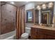 Elegant bathroom featuring a granite countertop, wood cabinets, and tiled shower with decorative accents and shuttered window at 3026 Wentworth Way, Tarpon Springs, FL 34688
