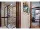 Modern bathroom showcasing a glass-enclosed shower with decorative tiling and a glimpse of a home office at 3026 Wentworth Way, Tarpon Springs, FL 34688
