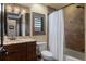 Stylish bathroom featuring granite countertops, wood cabinets, tiled shower, and a window with shutters for natural light at 3026 Wentworth Way, Tarpon Springs, FL 34688
