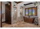 Luxurious bathroom features a soaking tub, travertine floors, dual shower heads, and plantation shutters at 3026 Wentworth Way, Tarpon Springs, FL 34688