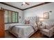 Comfortable bedroom with tufted headboard, hardwood floors, neutral tones, and natural light at 3026 Wentworth Way, Tarpon Springs, FL 34688