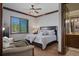 Comfortable bedroom with hardwood floors, a large window with shutters, and a serene view, adjacent to an ensuite bathroom at 3026 Wentworth Way, Tarpon Springs, FL 34688