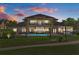 Stately multi-story home featuring a manicured lawn and in-ground pool at dusk at 3026 Wentworth Way, Tarpon Springs, FL 34688