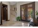 Inviting foyer with a staircase, elevator, and double doors leading to a landscaped outdoor area at 3026 Wentworth Way, Tarpon Springs, FL 34688