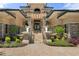 The home's inviting front entrance features stone pillars, an archway, and manicured landscaping at 3026 Wentworth Way, Tarpon Springs, FL 34688