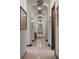 Long hallway with beautiful arches, decorative lighting and wall sconces, with stone floors and baseboards at 3026 Wentworth Way, Tarpon Springs, FL 34688