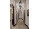 Elegant hallway featuring travertine floors, stylish sconces, and decorative hanging lanterns with recessed ceiling feature at 3026 Wentworth Way, Tarpon Springs, FL 34688