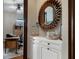Elegant hallway featuring a white cabinet with decorative accents, modern mirror, and a glimpse into a well-appointed office at 3026 Wentworth Way, Tarpon Springs, FL 34688