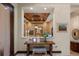 Hallway view of the wine room and sitting area which includes a charming table, ottoman, and decorative wall art at 3026 Wentworth Way, Tarpon Springs, FL 34688