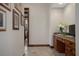 Well-lit hallway showing a built-in desk and marble counters, with travertine floors, and framed pictures at 3026 Wentworth Way, Tarpon Springs, FL 34688