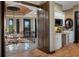 Hallway on second floor overlooking foyer showcasing chandelier, and kitchenette with microwave and white cabinets at 3026 Wentworth Way, Tarpon Springs, FL 34688