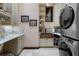 Well-appointed laundry room with stone counters, copper sink, and stacked washer and dryer at 3026 Wentworth Way, Tarpon Springs, FL 34688