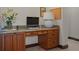 Close up of an office nook featuring built-in desk and cabinets with marble counters and travertine floors at 3026 Wentworth Way, Tarpon Springs, FL 34688