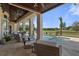Covered outdoor patio featuring ceiling fans, travertine tile and a serene view of the pool and golf course at 3026 Wentworth Way, Tarpon Springs, FL 34688