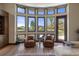 Bright sitting area features two armchairs and large windows overlooking the landscaped yard at 3026 Wentworth Way, Tarpon Springs, FL 34688