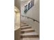 Elegant staircase with neutral-toned marble steps and curved wall, enhanced by stylish decor and a sleek black handrail at 3026 Wentworth Way, Tarpon Springs, FL 34688