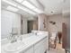 This is a full bathroom with double sinks, a walk-in shower, a neutral tile scheme, and modern fixtures at 305 Royal Palm Way, Spring Hill, FL 34608