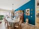 Elegant dining room with a large table set for a meal and a striking blue accent wall with unique decor at 305 Royal Palm Way, Spring Hill, FL 34608