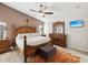 Spacious main bedroom with tray ceiling, dark furniture, TV, ceiling fan, and neutral color scheme at 305 Royal Palm Way, Spring Hill, FL 34608