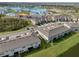 An aerial view of the residential area features cozy townhouses adjacent to a bright turquoise lagoon at 31718 Blue Passing Loop, Wesley Chapel, FL 33545