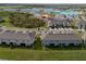 High aerial view of townhouses in a neighborhood with a bright turquoise lagoon in the distance at 31718 Blue Passing Loop, Wesley Chapel, FL 33545