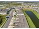 An aerial shot showcases neatly arranged townhouses next to a winding pond, surrounded by neighborhood streets at 31718 Blue Passing Loop, Wesley Chapel, FL 33545