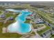 A scenic aerial view of a lagoon and its recreational area with the neighborhood beyond at 31718 Blue Passing Loop, Wesley Chapel, FL 33545