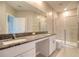 Bathroom featuring double sinks, granite countertops, and a glass-enclosed shower at 31718 Blue Passing Loop, Wesley Chapel, FL 33545