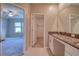 Bathroom with walk-in closet, granite countertop, and view into bedroom at 31718 Blue Passing Loop, Wesley Chapel, FL 33545
