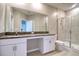 Bathroom featuring double sinks, granite countertops, and a glass-enclosed shower at 31718 Blue Passing Loop, Wesley Chapel, FL 33545