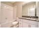 A bathroom features tiled walls, a shower-tub combo, granite counters and modern fixtures at 31718 Blue Passing Loop, Wesley Chapel, FL 33545